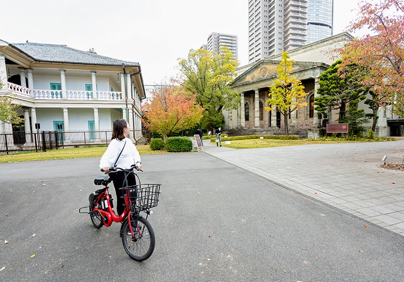 旧桜宮公会堂を眺める大阪バイクシェアを利用している女性