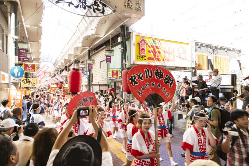 gal mikoshi in Tenjinbashisuji Shopping arcade, young women in festival costume carry golden portable shrine for Tenjin Matsuri
