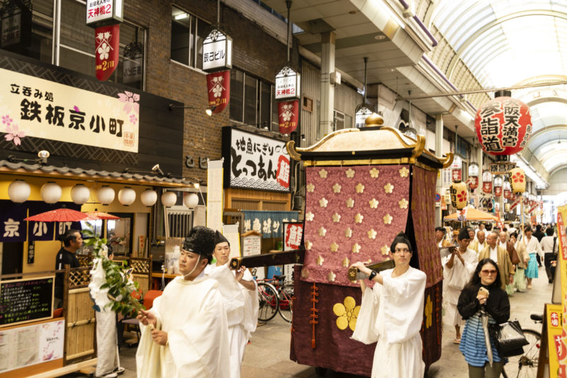 land procession festival floats are carried through Tenjinbashisuji Shopping Arcade by men in robes for Tenjin festival