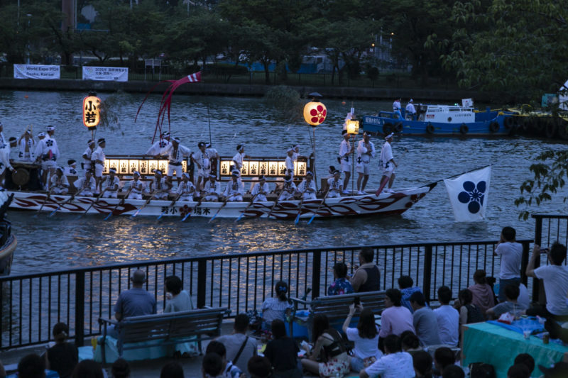 dondoko boats full of rowers on river and illuminated by lanterns for Tenjin Matsuri Festival