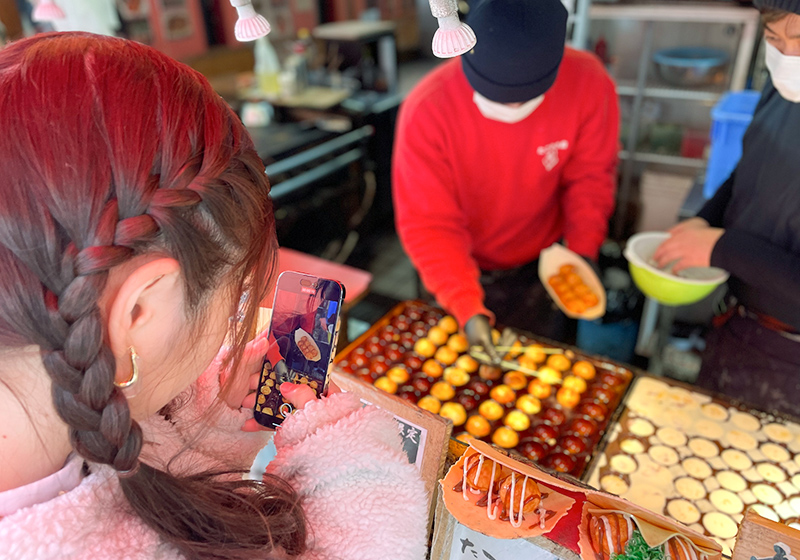 粉もん「たこやき座」のたこ焼きの写真を撮るNMB48の出口結菜
