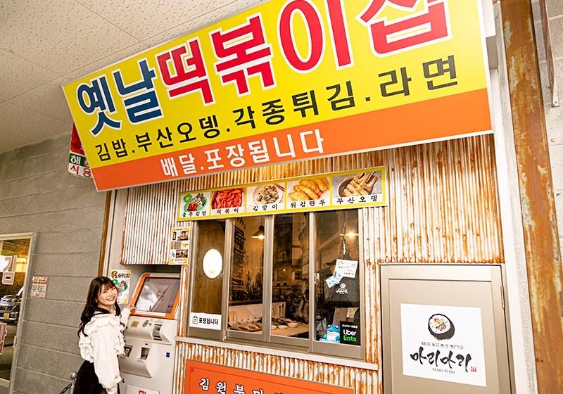 韓国海苔巻き専門店のマリマリ大阪コリアタウン店の店前にいるNMB48の出口結菜