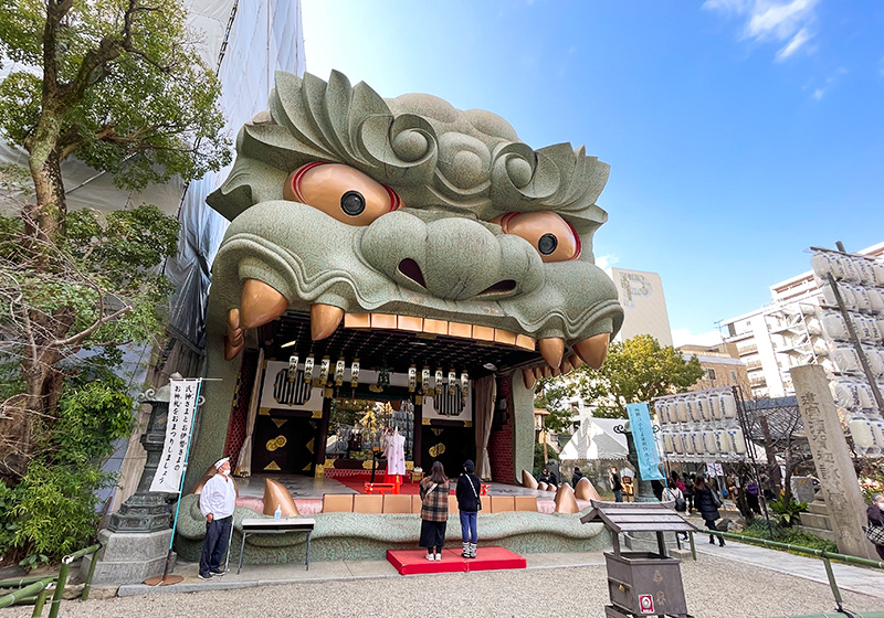 lion-head shrine in Osaka with big gold eyes and stage at Namba Yasaka Jinja