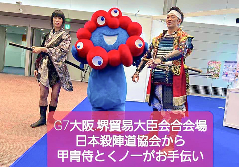 samurai and female ninja posing with Myaku-Myaku for the G7 finance ministers meeting in Osaka