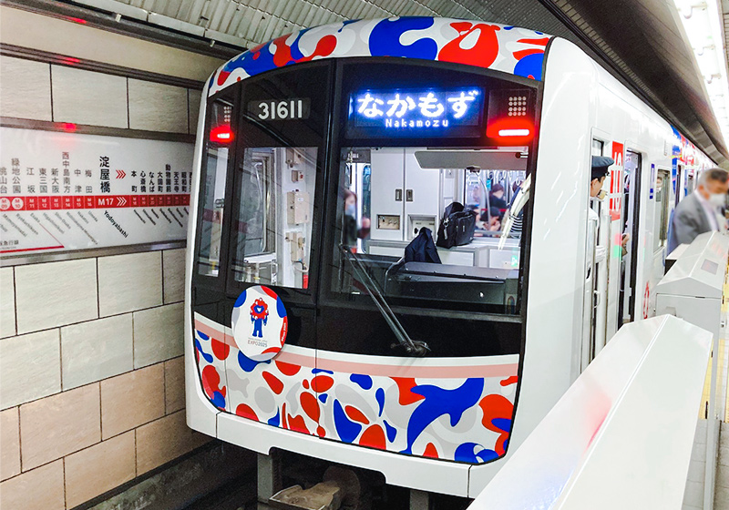 red, white, and blue Osaka Expo themed trains on the Osaka Metro