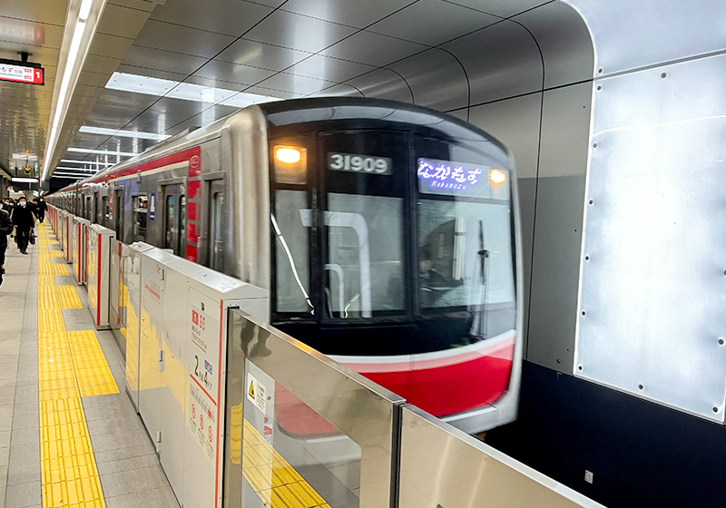 Osaka Metro Midosuji Line train with a silver exterior and red line