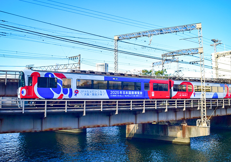 Red, white, and blue Kansai Osaka Expo themed Keihan train
