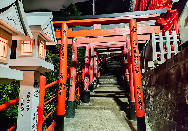 night walk at tunnels of torii gates at Shigisan Temple in Nara lit by stone lanterns