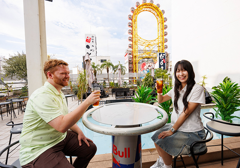 道頓堀の観覧車を背景に乾杯する様子